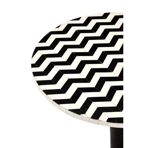 Round side table featuring a mosaic design with a zigzag pattern in black and white, crafted from acacia wood. The table has a sleek pedestal base, emphasizing its modern aesthetic