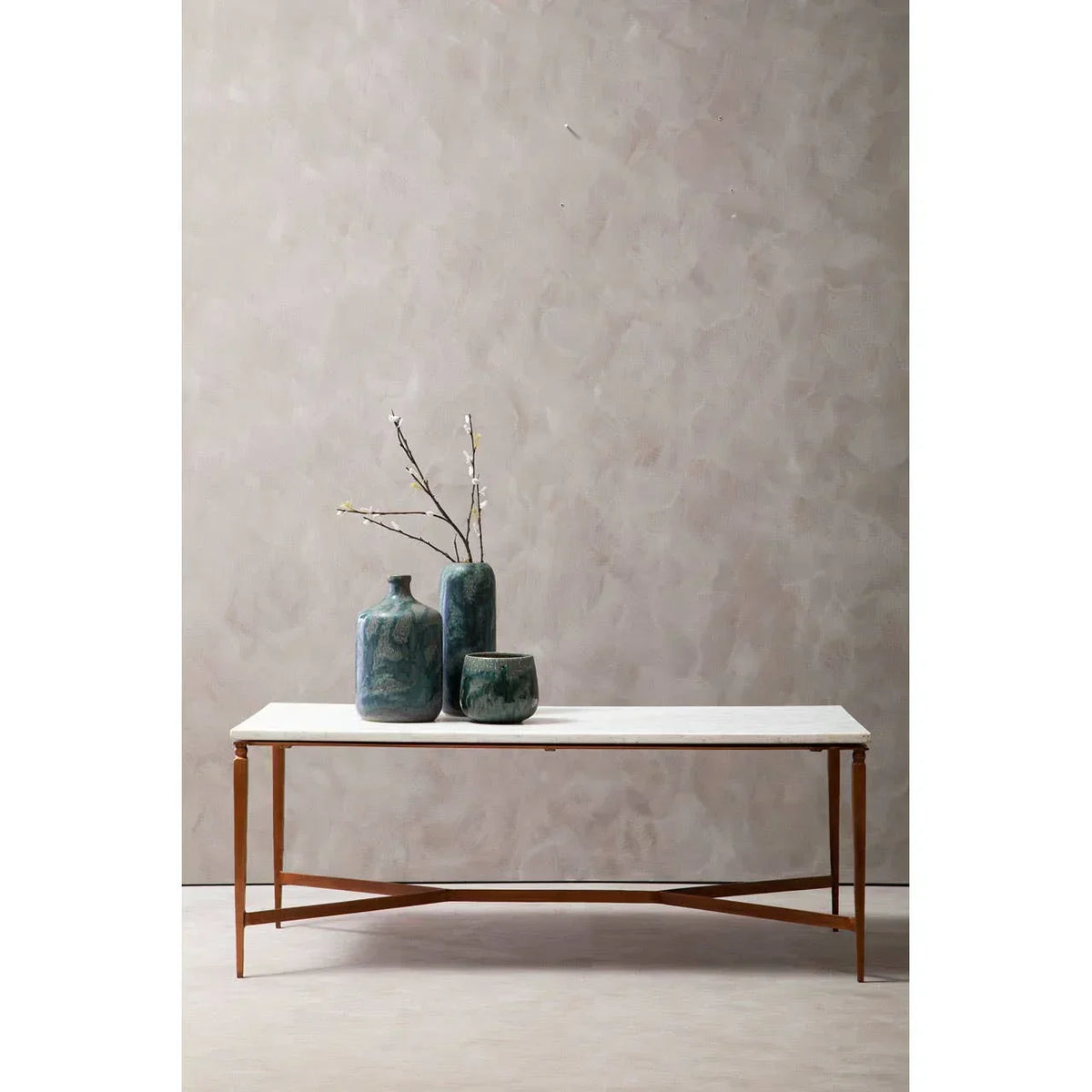 marble top coffee table with gold metal frame styled with green ceramic vases