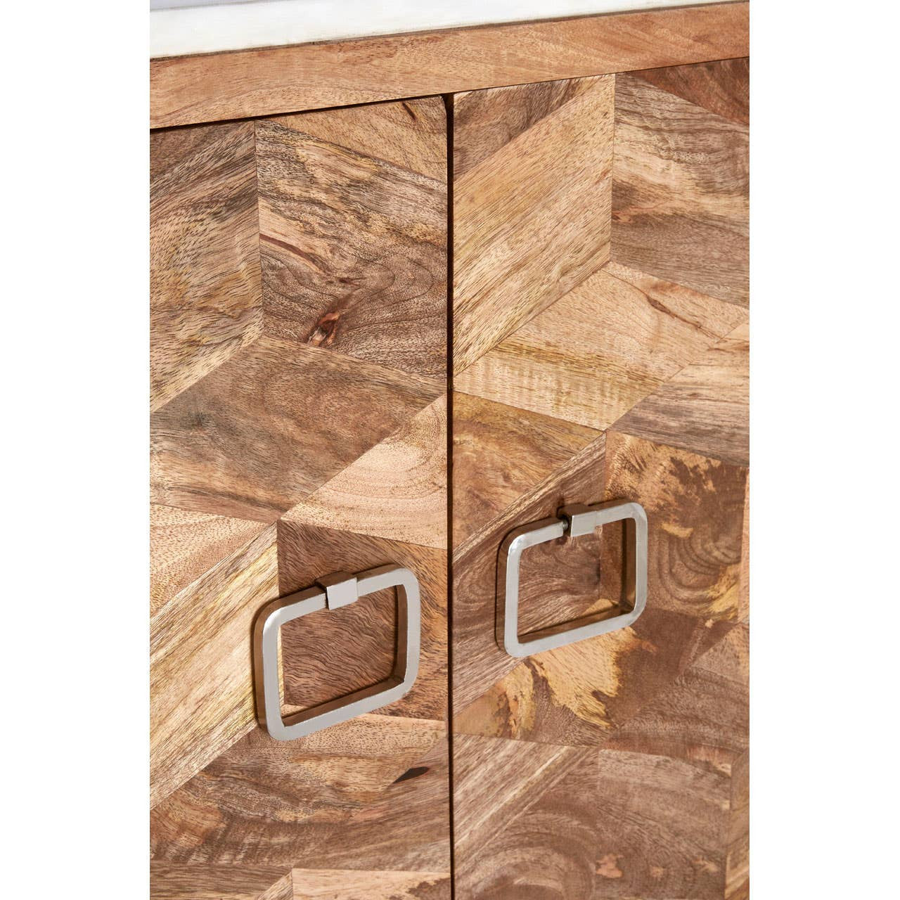 Close-up view of a cabinet featuring a geometric design made from mango wood, showcasing a rich wood grain pattern. The cabinet has two doors with sleek square metal handles, highlighting a modern aesthetic. The top surface appears to be made of marble, adding an elegant touch to the overall design