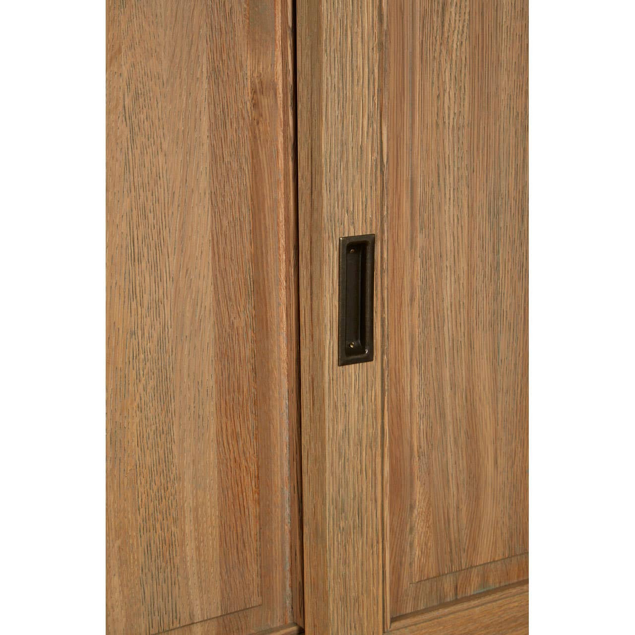 Tall cabinet made of oak wood featuring a washed grey finish, showcasing a smooth surface with a minimalist design and a sleek handle integrated into the door. The wood grain is visible, highlighting the natural texture and color variations