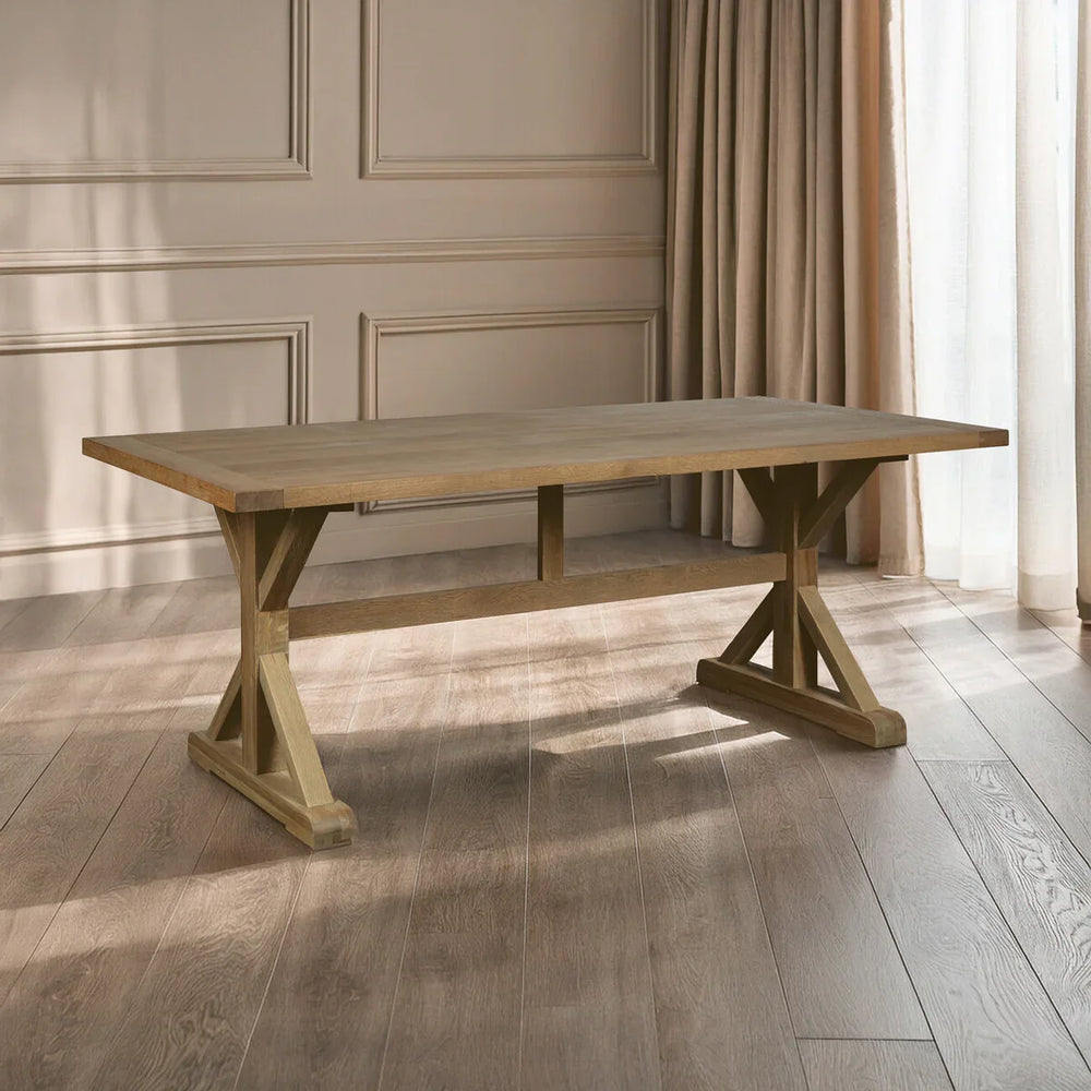 Wooden dining table with trestle legs on oak flooring in a bright room