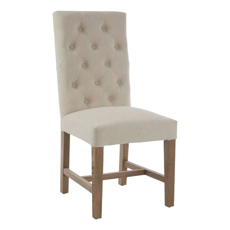Beige upholstered dining chair with button-tufted back and wooden legs, front angle view