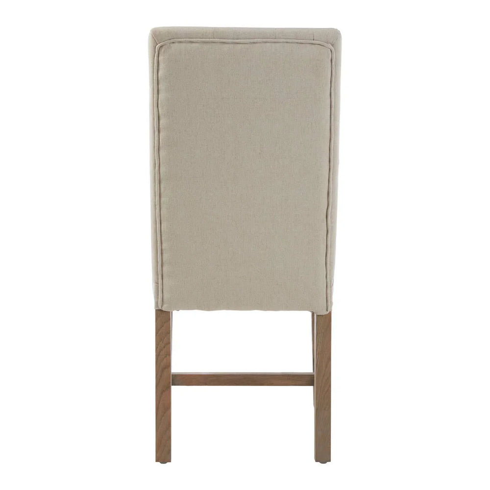 Beige upholstered dining chair rear view with wooden legs and stitched panel detailing
