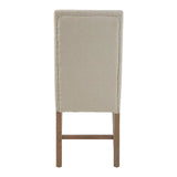 Beige upholstered dining chair rear view with wooden legs and stitched panel detailing
