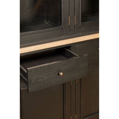Close-up view of a black oak wood cabinet featuring a single drawer with a round handle, showcasing a sleek design and a smooth finish. The cabinet has a minimalist aesthetic with clean lines and a natural wood grain texture