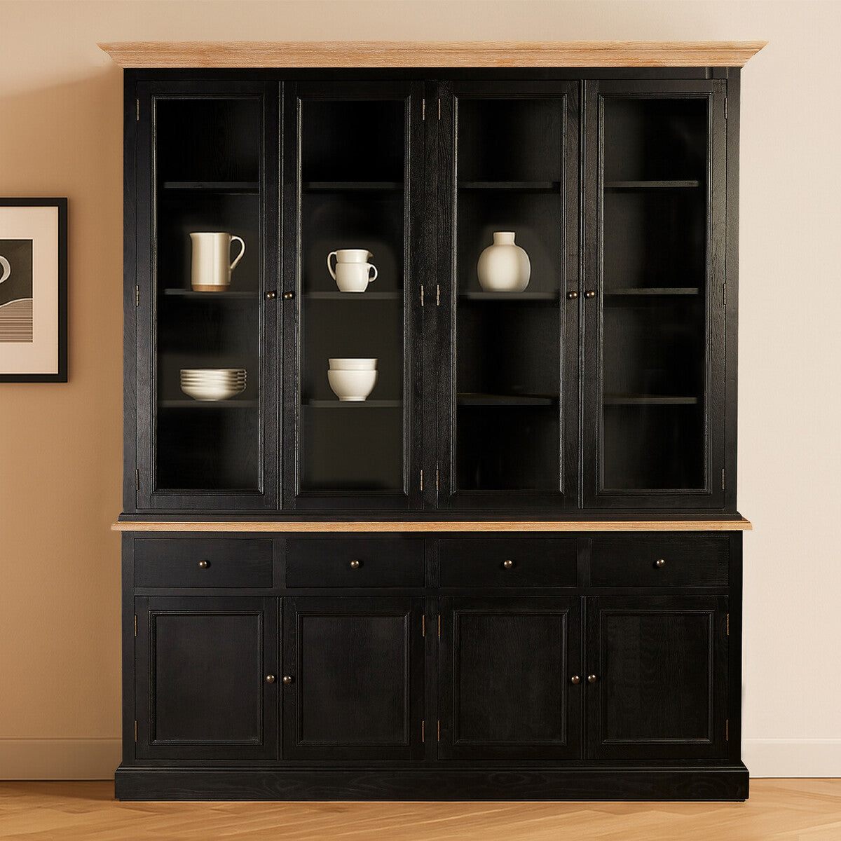 Large black oak wood cabinet featuring multiple shelves and glass doors, displaying decorative items such as vases and dishes. The cabinet has a smooth top surface and a lower section with closed storage, set against a neutral wall with a framed picture nearby