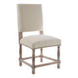 Beige upholstered dining chair with wooden legs and nailhead trim on white background