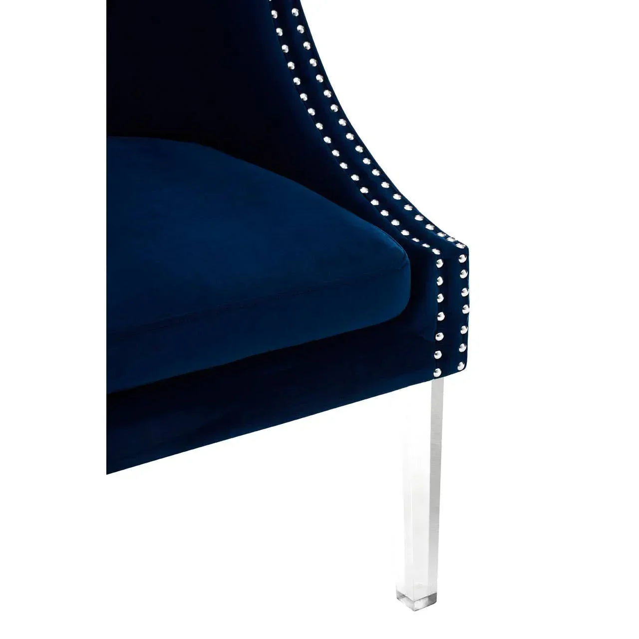 Blue velvet accent chair with silver stud trim and clear acrylic leg, close-up view