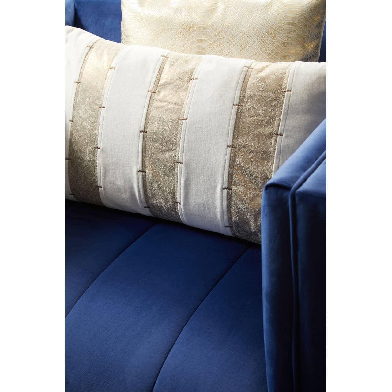 Blue velvet sofa with cream and gold accent cushion on seat