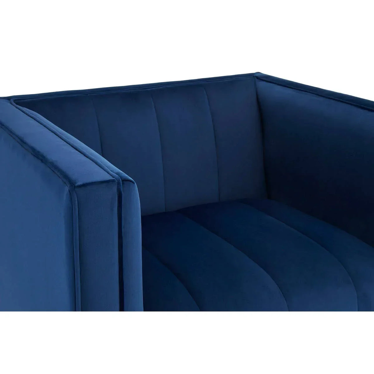 Blue velvet armchair with deep seat and vertical stitched upholstery, close side angle