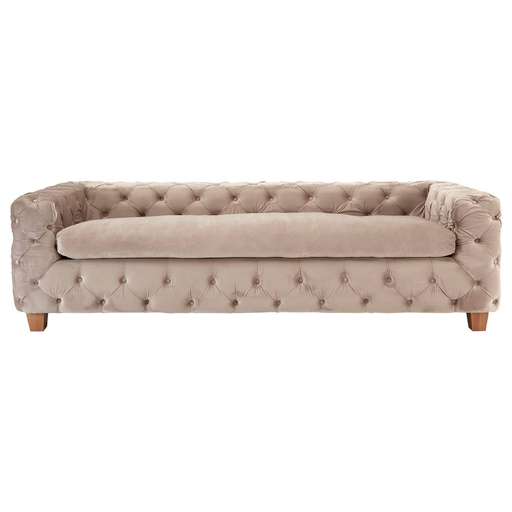 Beige velvet sofa with a tufted design, featuring a low back and thick seat cushion, supported by wooden legs. The overall style is elegant and modern, suitable for a living room setting