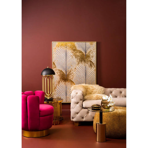 Beige velvet sofa with three seats, featuring tufted detailing and wooden legs, positioned in a stylish living room setting with a deep red wall, a large abstract artwork, a pink accent chair, and a gold side table