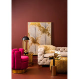Beige velvet sofa with three seats, featuring tufted detailing and wooden legs, positioned in a stylish living room setting with a deep red wall, a large abstract artwork, a pink accent chair, and a gold side table
