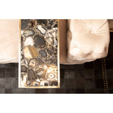 Beige velvet three-seat sofa with plush cushions, positioned next to a decorative coffee table featuring an abstract design in shades of brown and gold. The sofa's soft texture and elegant design complement the modern decor of the room