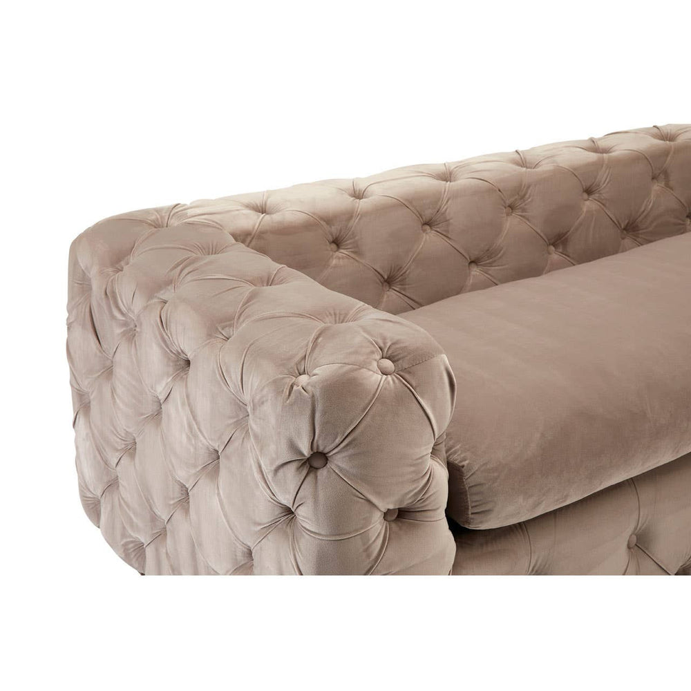Beige velvet sofa with a tufted design, featuring a low backrest and plush cushions, showcasing a rounded armrest with button detailing