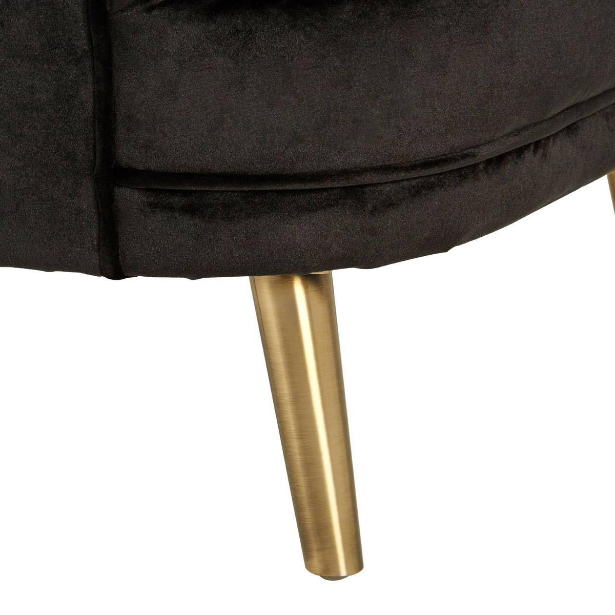 Closeup of black velvet chair with gold metal tapered leg