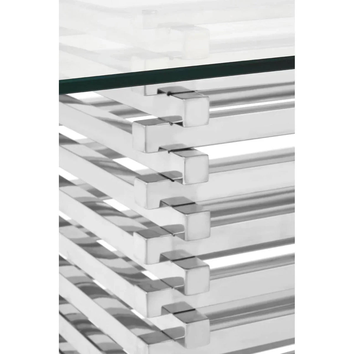 Closeup of glass coffee table with chrome metal frame and modern stacked design