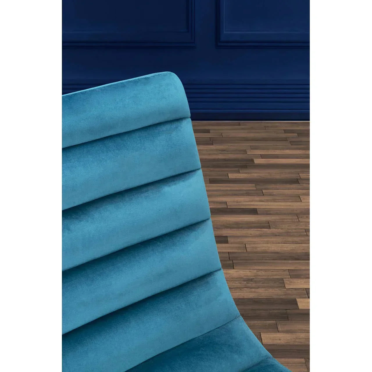 Blue velvet dining chair backrest with channel tufting on wood flooring