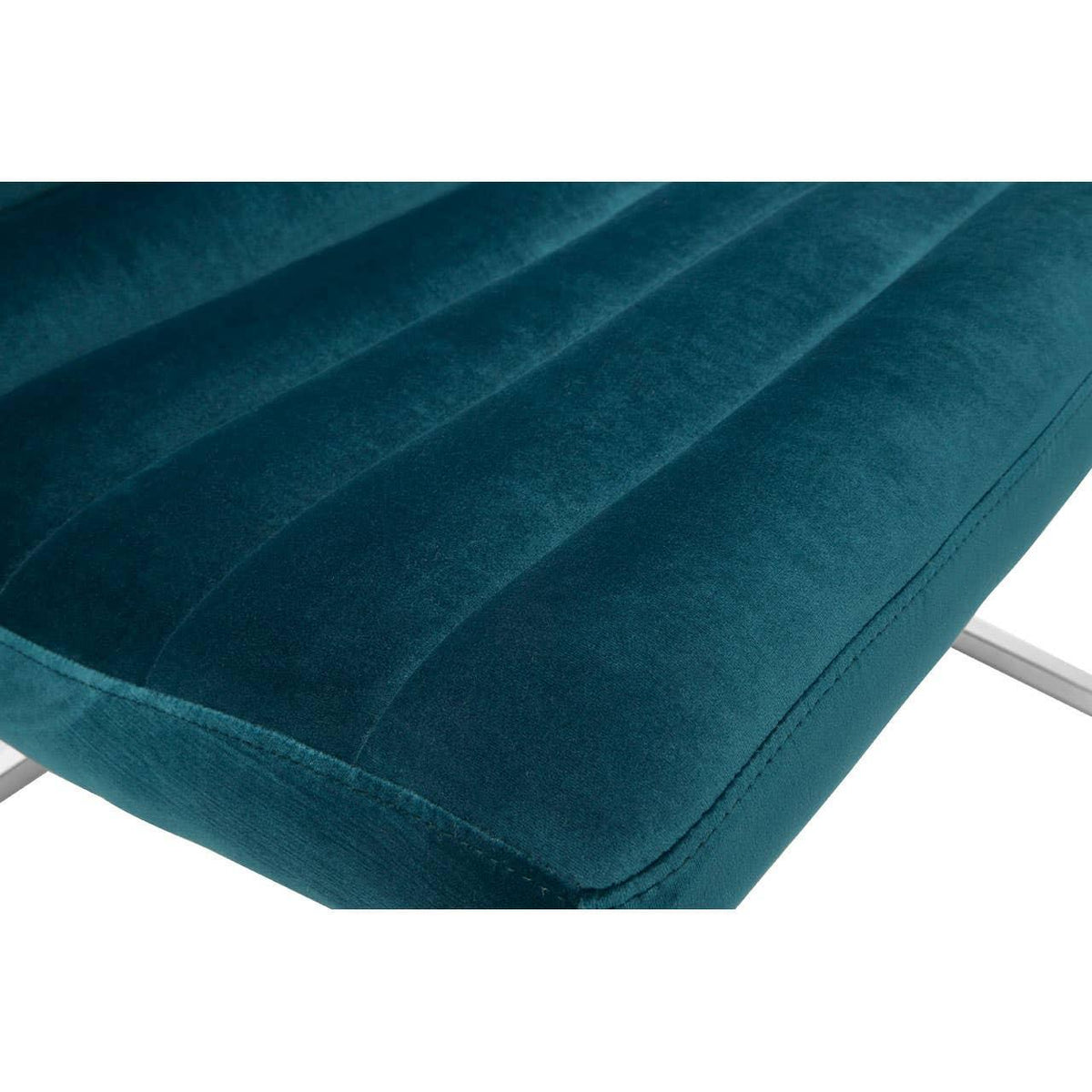 Teal velvet chair seat with vertical stitching and chrome legs, close-up view