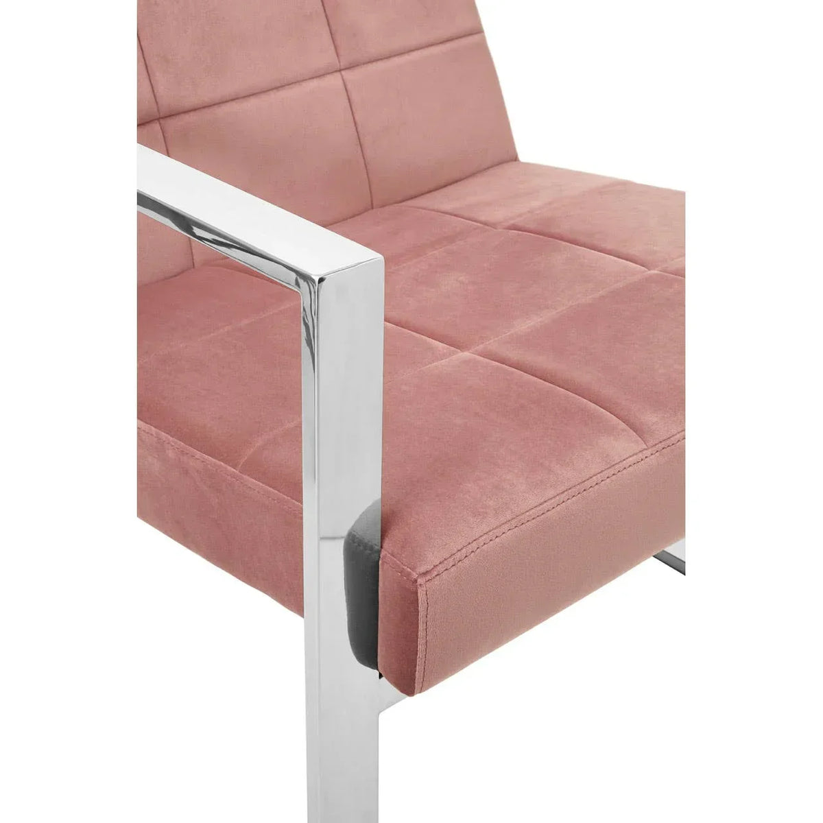 Velvet dining chair with pink upholstery and chrome armrest detail