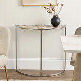 Half moon console table featuring a white agate top with natural patterns, supported by a sleek metal frame. A black vase with dried flowers sits on the table, accompanied by light-colored chairs and a neutral wall in the background
