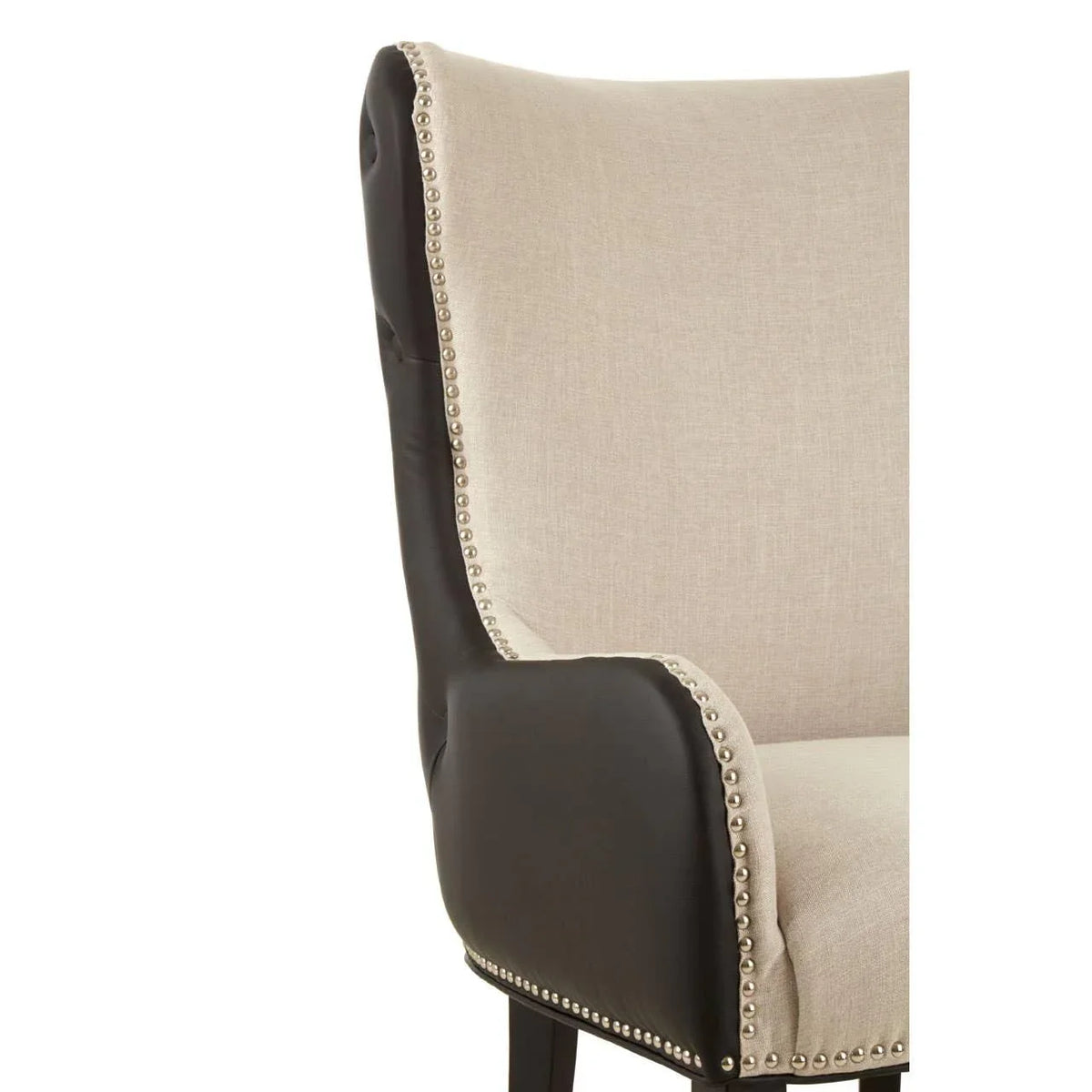 Beige fabric armchair with black leather sides and silver nailhead trim closeup
