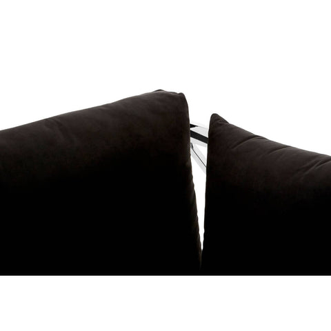 Close-up view of the black velvet upholstery on a three-seater sofa, highlighting the seam between two cushions. The fabric appears soft and plush, with a subtle sheen. The edges of the cushions are neatly finished, showcasing the quality of the material