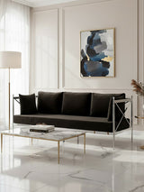 A sleek three-seater sofa upholstered in black velvet, featuring a modern silver frame. The sofa is positioned in a bright room with large windows, complemented by a minimalist coffee table and an abstract artwork on the wall. Soft natural light enhances the elegant design and luxurious texture of the fabric