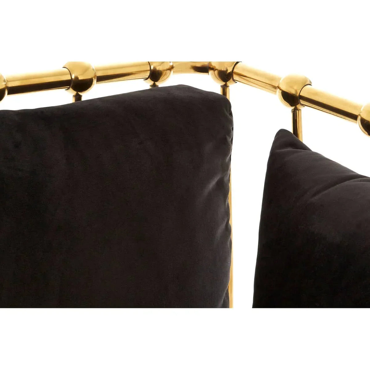 Closeup of black velvet sofa cushions with gold metal frame detail
