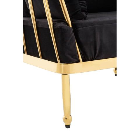 Black velvet upholstery covers the seat and backrest of a modern three-seater sofa, featuring a sleek gold finish on the frame and legs. The design includes vertical gold bars on the sides, adding a touch of elegance. The legs are tapered and end in small black caps
