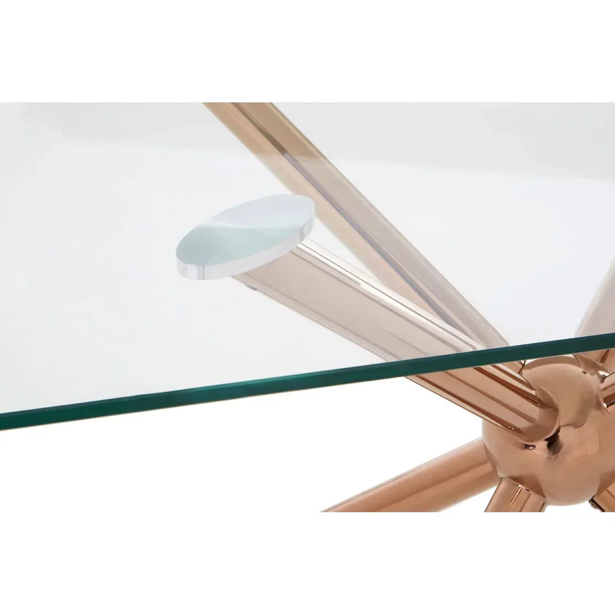 Glass dining table with gold metal legs and clear top closeup