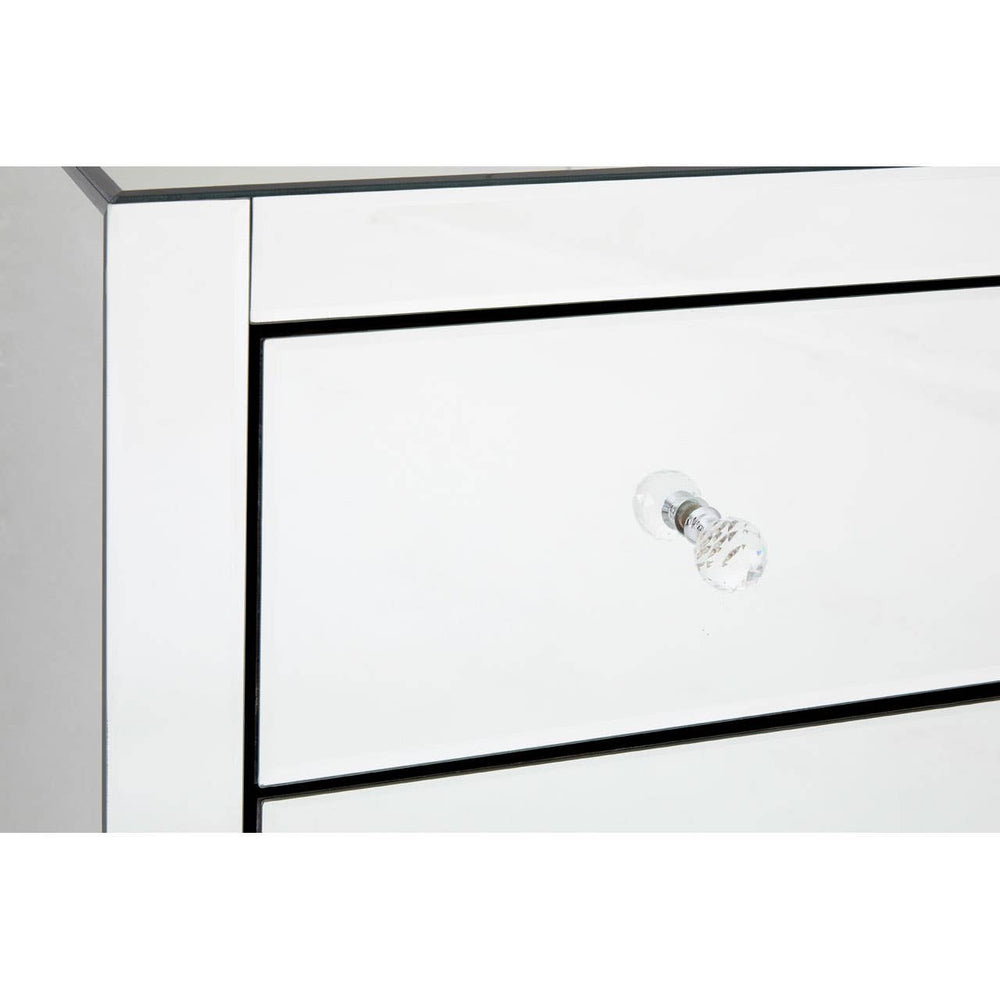 A close-up view of the Graciela Chest of 4 Drawers, featuring a sleek white finish with a subtle black outline around the drawers. Each drawer has a simple, elegant silver knob for easy access. The surface is smooth and reflective, enhancing the modern aesthetic of the furniture piece