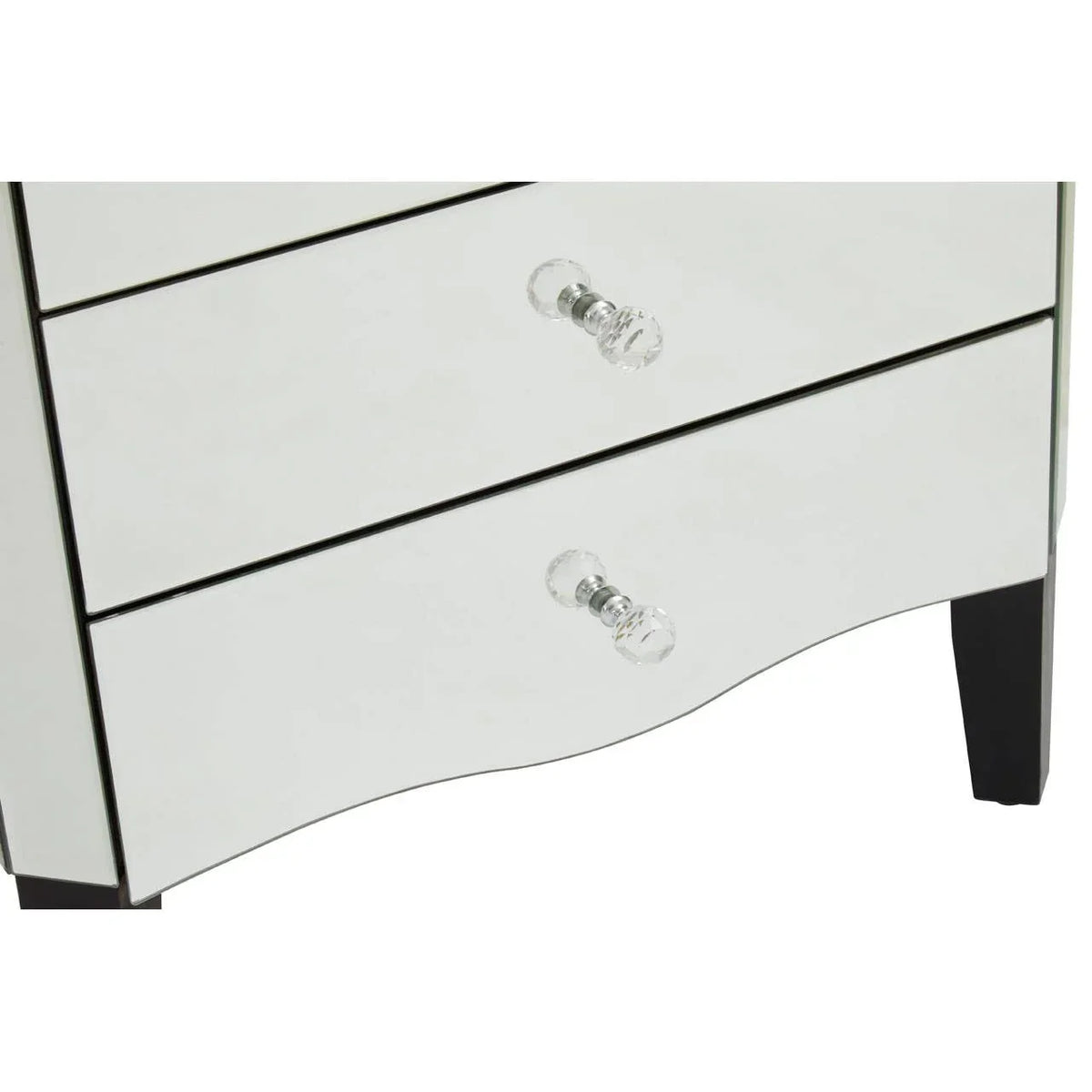 Mirrored chest of drawers with glass handles and black legs, close-up lower section