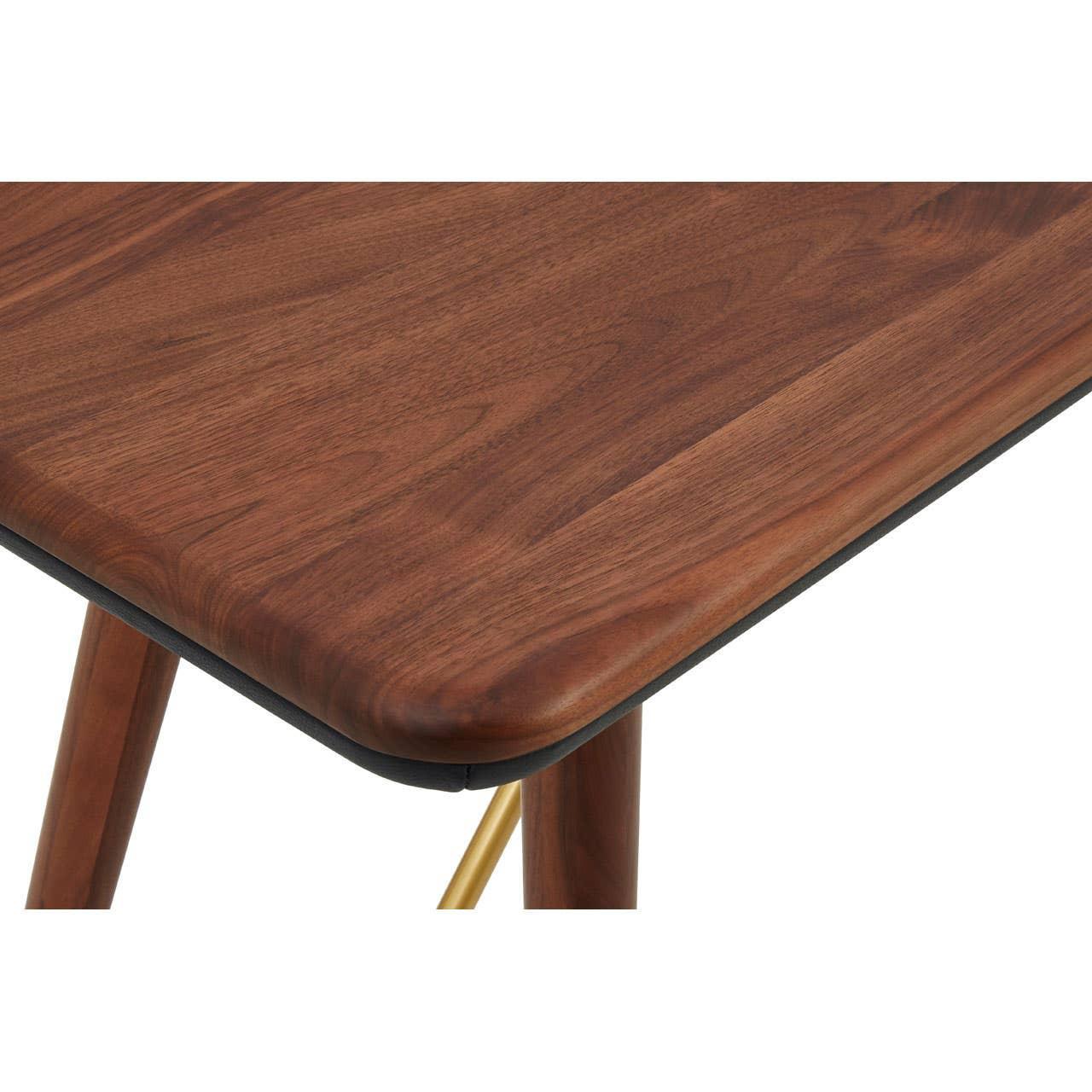 Close-up of walnut dining table corner with rounded edge and wooden legs