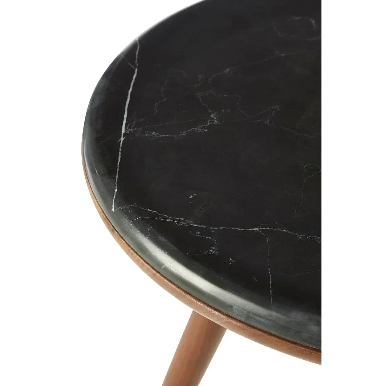 Round black marble table top with white veining on wooden legs, close detail view