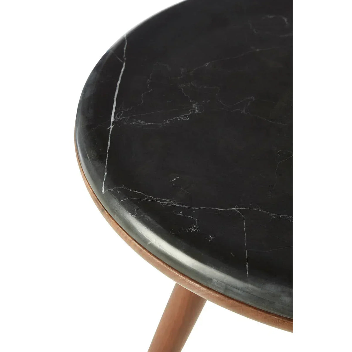 Round black marble table top with white veining on wooden legs, close detail view