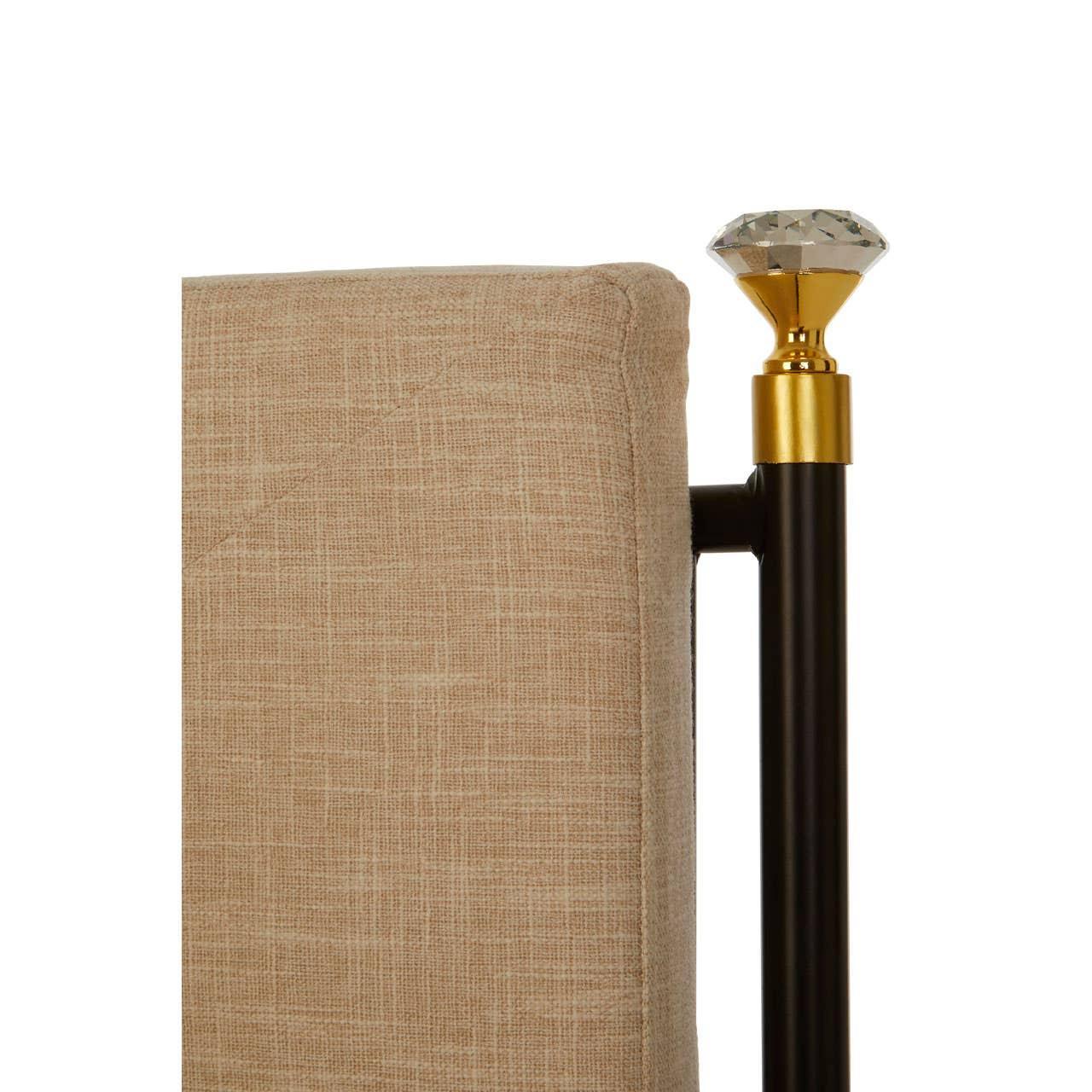 Beige fabric bed headboard corner with black metal post and decorative crystal finial