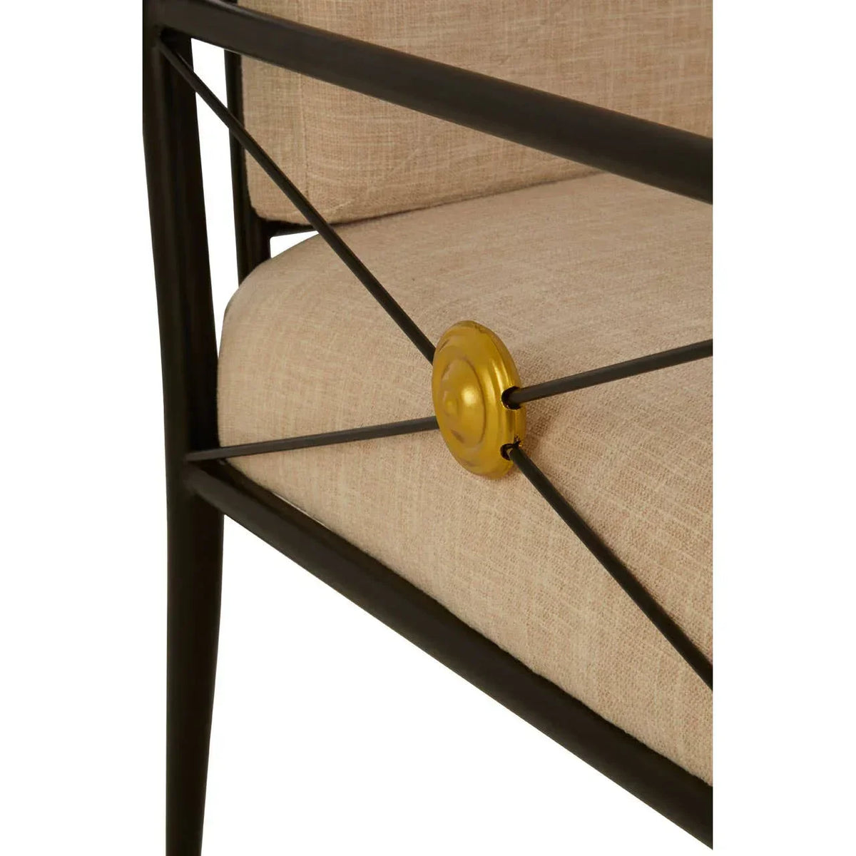 Detail of metal frame accent chair with beige cushion and gold decorative medallion
