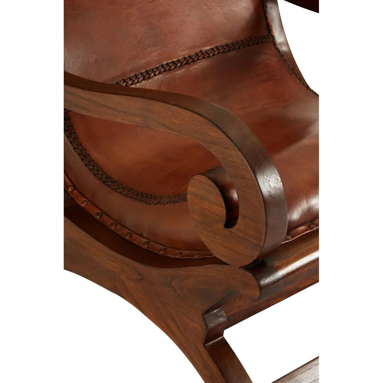 Close-up of brown leather armchair with curved wooden armrest and stitched trim detail