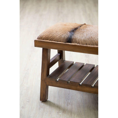 Wooden bench with slatted shelf and brown fur upholstered seat on light wood floor
