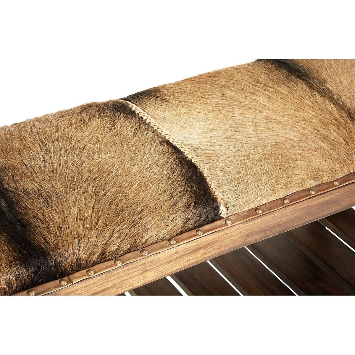 Brown cowhide bench seat with wooden frame and decorative metal studs, close-up view