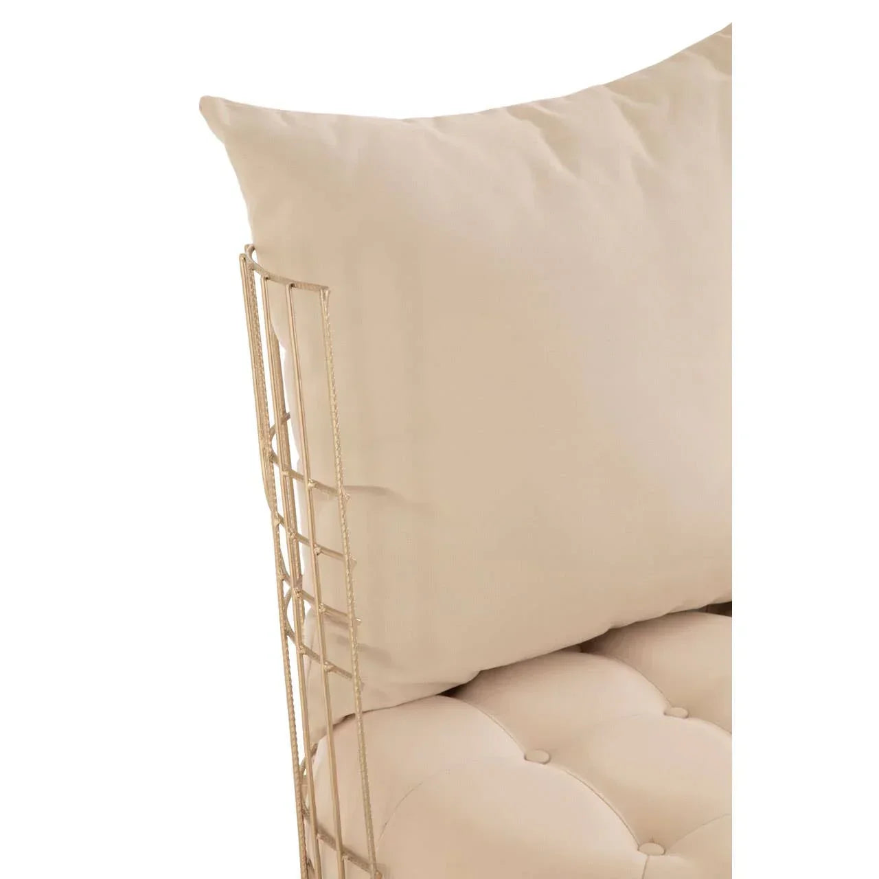 Close up of beige tufted sofa cushion with gold metal frame and matching pillow