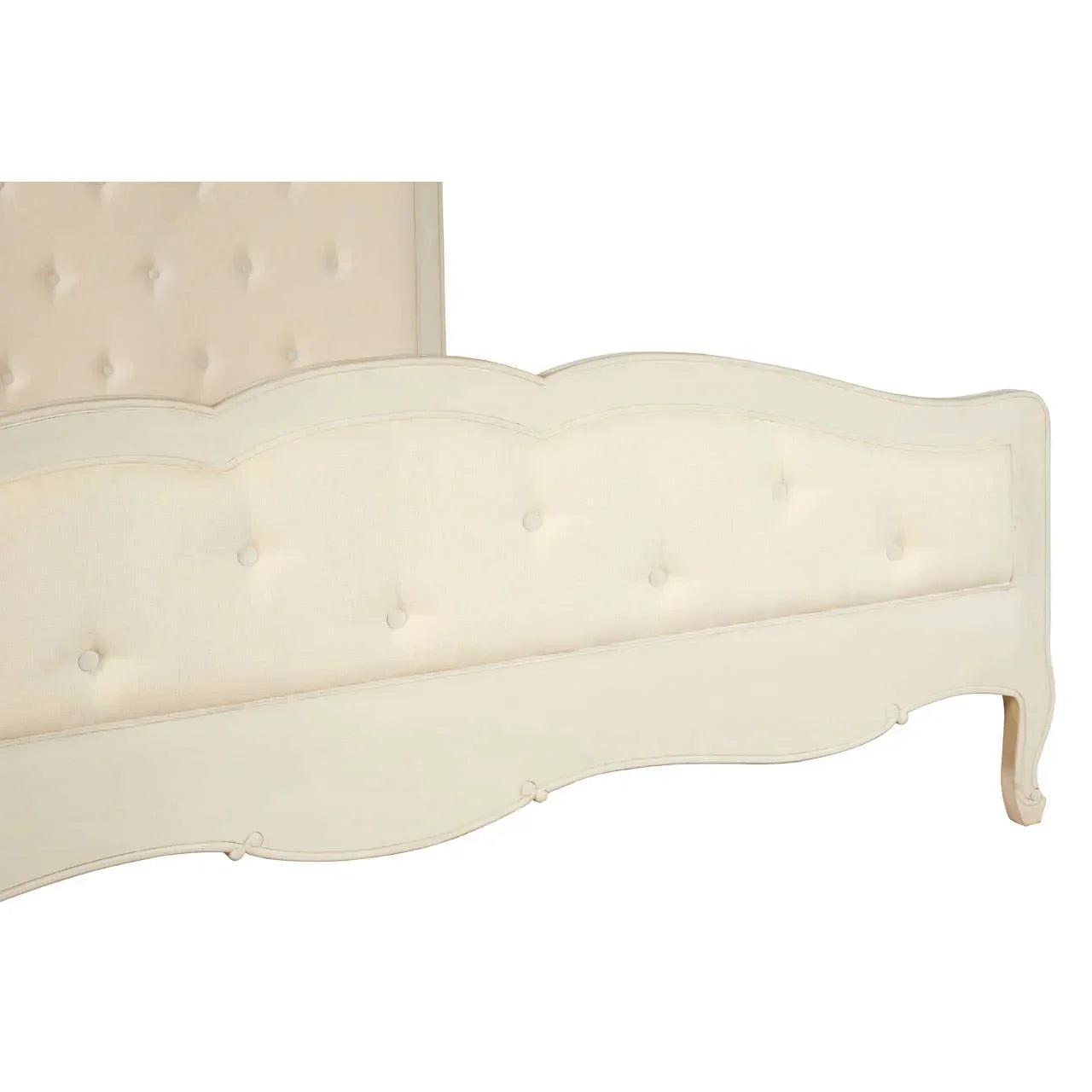 Cream upholstered bed frame with button tufted footboard and curved wood detailing