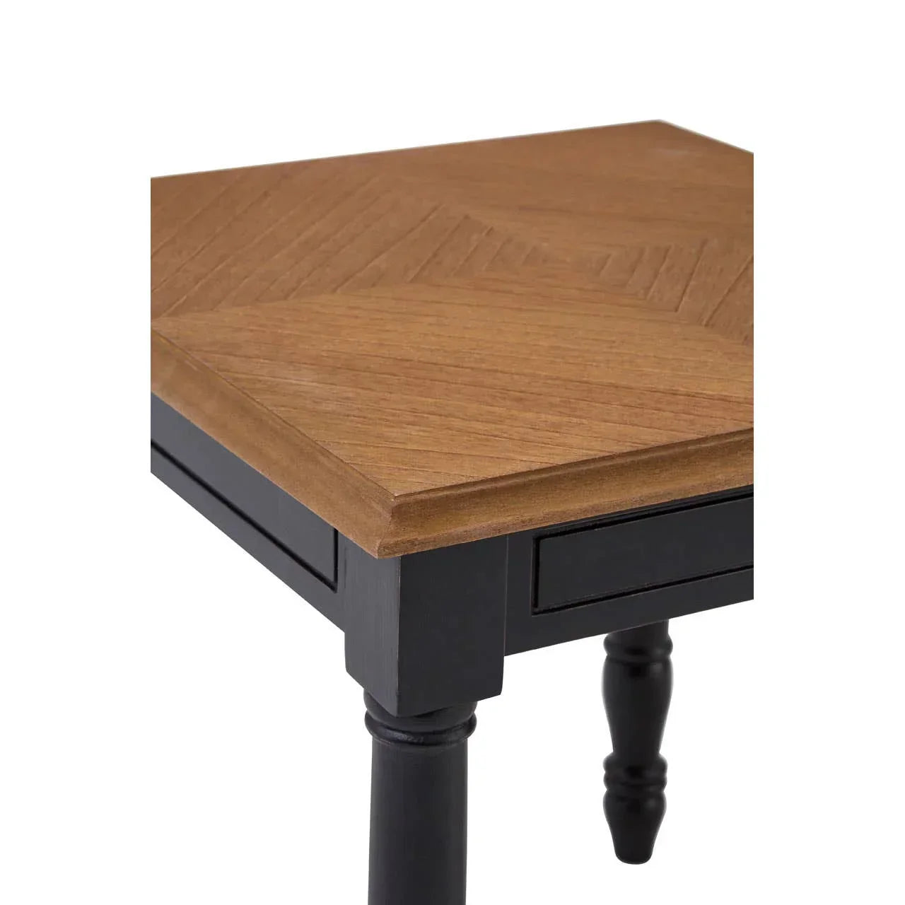 Closeup of wooden dining table corner with black turned legs and patterned tabletop