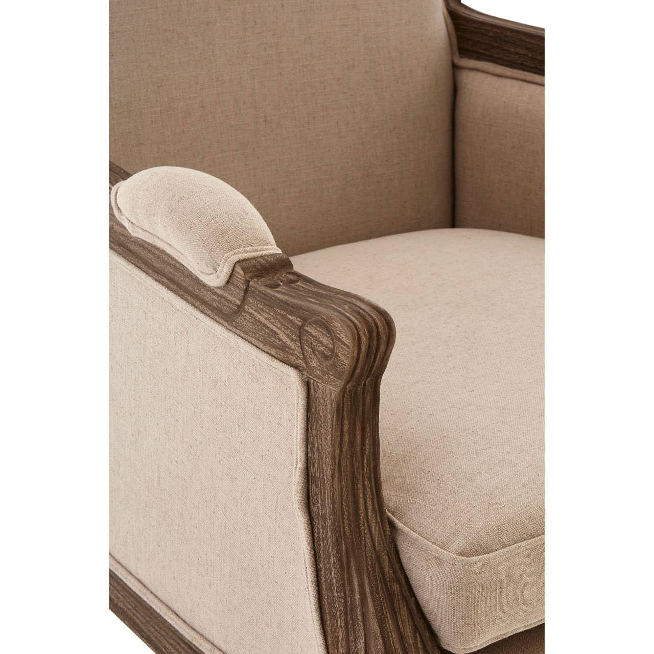 Beige upholstered armchair with carved wood frame and padded armrest detail
