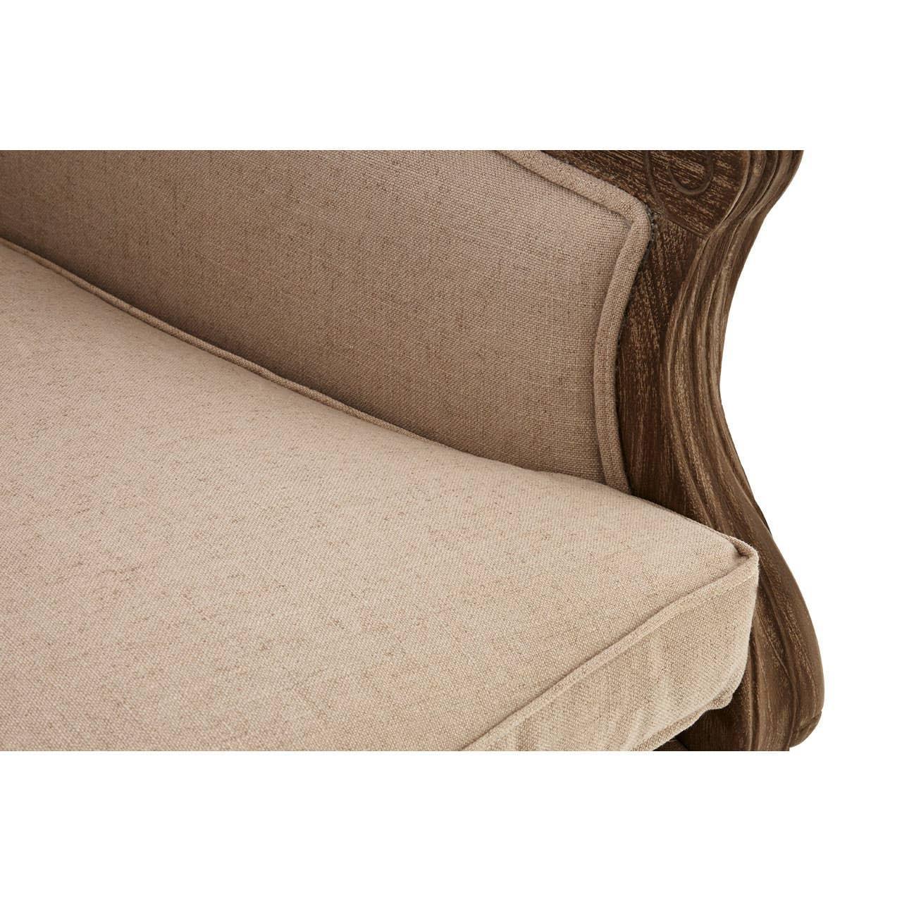 Beige upholstered sofa cushion and carved wooden arm detail close-up