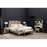 Champagne gold and mirrored stool with a sleek design, featuring a reflective surface and elegant legs, placed in a stylish bedroom setting that includes a bed with a tufted headboard, matching nightstands, and a decorative mirror against a dark wall