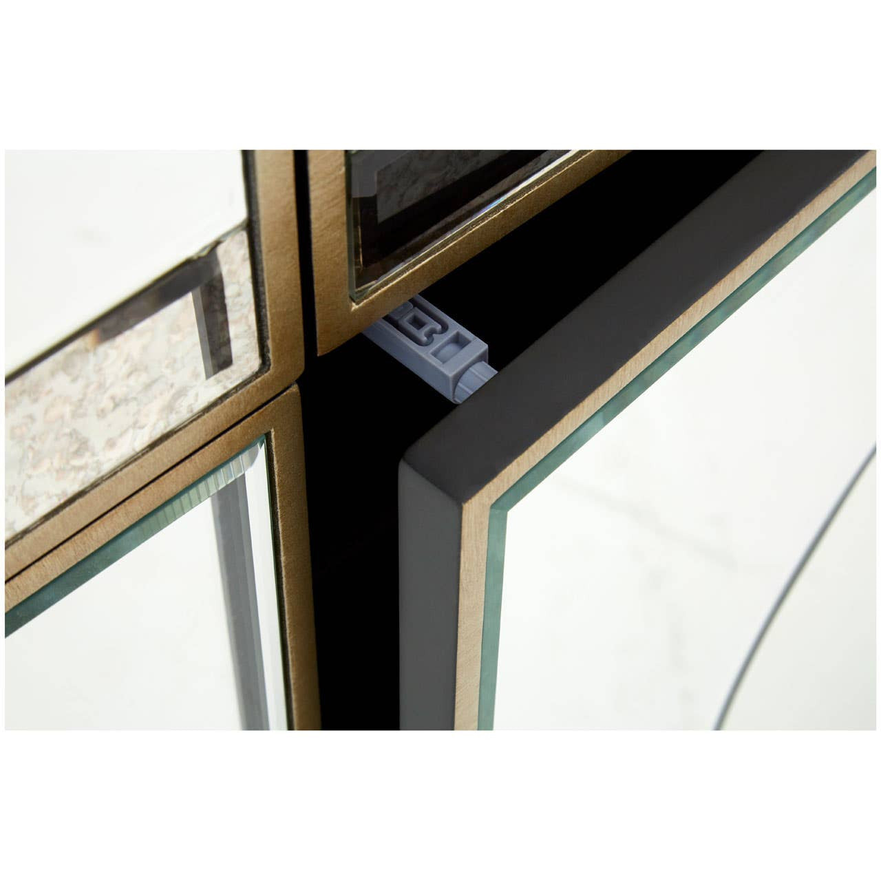 Champagne gold and mirrored sideboard featuring a sleek design with a reflective surface, showcasing elegant geometric lines and a polished finish. The corners are accented with gold trim, enhancing the luxurious appearance