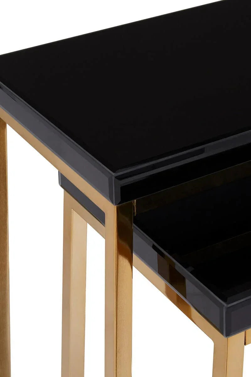 Black glass nest of tables with gold metal legs, close-up of corner design