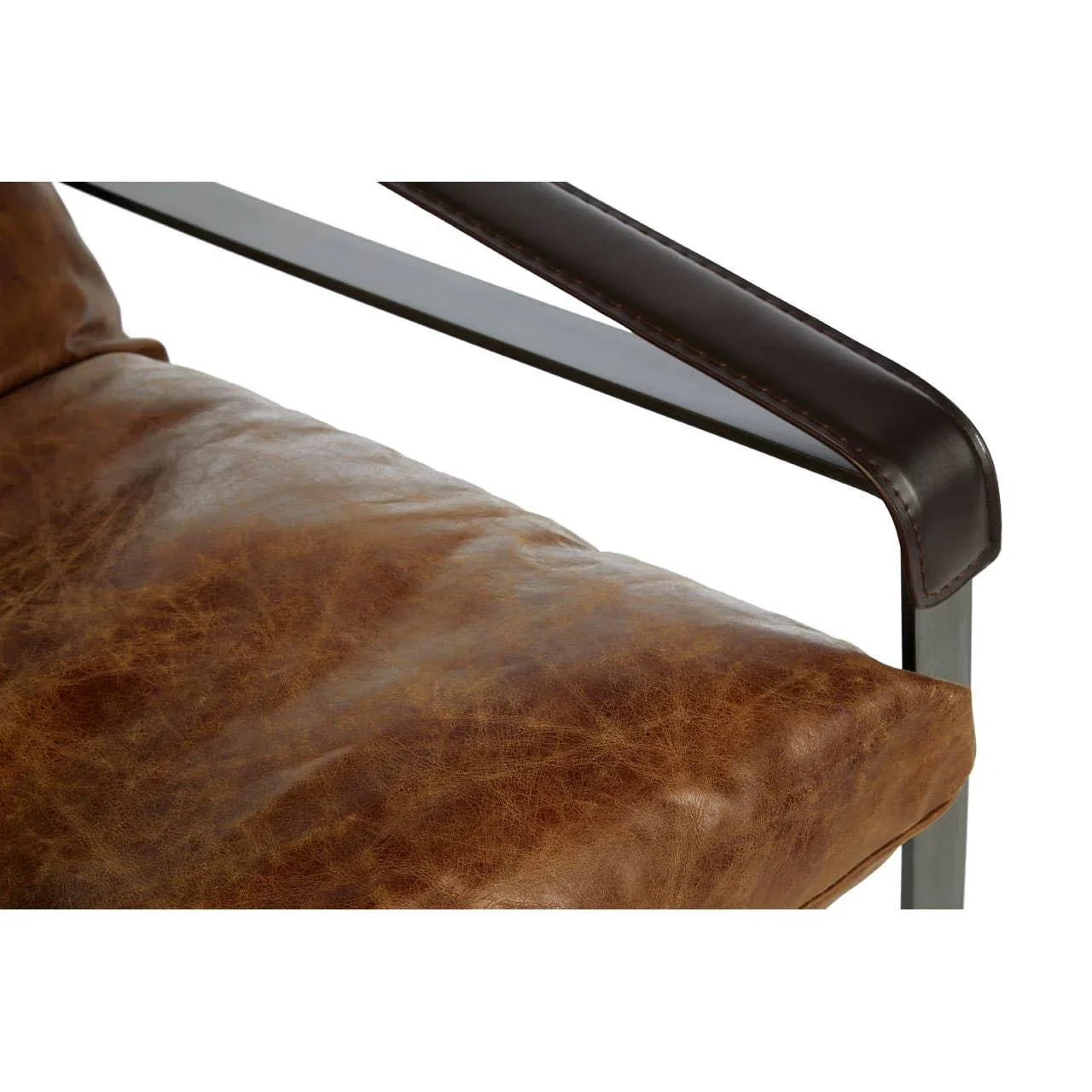 Brown leather armchair cushion and metal frame close up